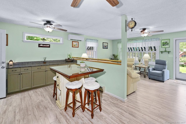 47 Little Bungee Hill Rd, Woodstock, CT 06282 - kitchen with a ceiling fan, an AC wall unit, a textured ceiling, light wood-type flooring, and dark countertops