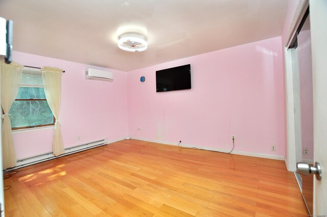 8 Pons Rd, Groton, CT 06355 - spare room featuring baseboard heating, a wall unit AC, and light wood-style flooring