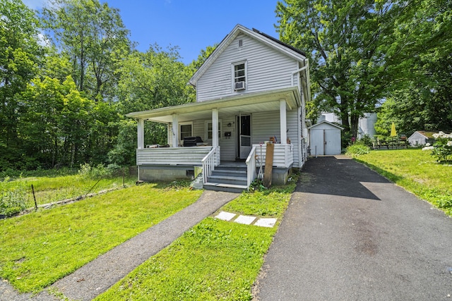 42 Goodwin St, Torrington, CT 06790 - view of front facade with a shed, a porch, asphalt driveway, a front yard, and cooling unit
