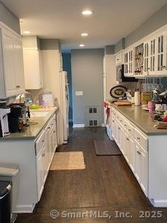 7 White Birch Rd, Wilton, CT 06897 - kitchen with white cabinetry, glass insert cabinets, recessed lighting, dark wood-style floors, and fridge