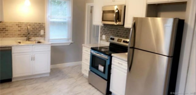476 Park Ave, Bloomfield, CT 06002 - kitchen with stainless steel appliances, backsplash, white cabinetry, and light countertops