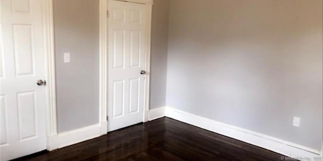 476 Park Ave, Bloomfield, CT 06002 - unfurnished bedroom with baseboards and dark wood-style flooring