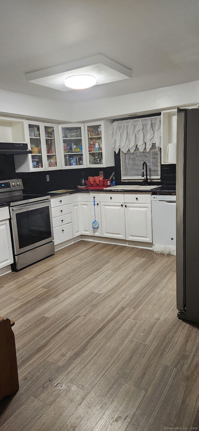 kitchen featuring electric range, freestanding refrigerator, dark countertops, and white dishwasher