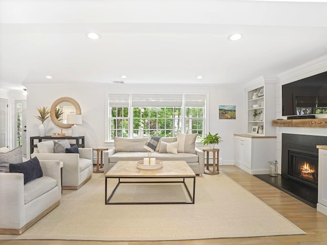 362 Joan Dr, Fairfield, CT 06824 - living room with wood finished floors, crown molding, a lit fireplace, recessed lighting, and built in features