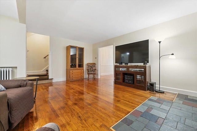 12 Deacon Hill Rd, Stamford, CT 06905 - living area featuring radiator, stairs, and wood finished floors