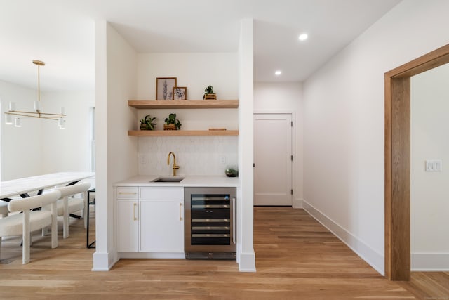 1846 Mill Plain Rd, Fairfield, CT 06824 - indoor wet bar with beverage cooler, decorative backsplash, light wood-style flooring, and recessed lighting