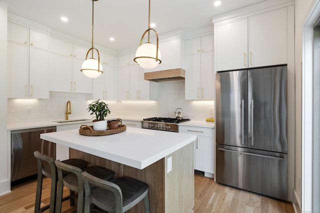 1846 Mill Plain Rd, Fairfield, CT 06824 - kitchen featuring stainless steel appliances, a kitchen island, decorative backsplash, light wood-style flooring, and recessed lighting