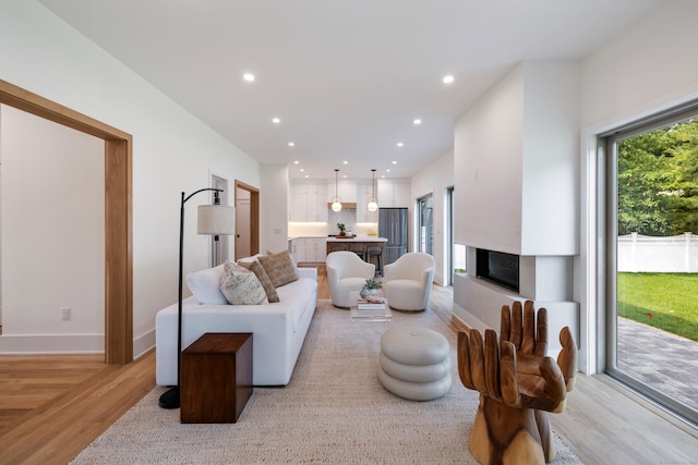 1846 Mill Plain Rd, Fairfield, CT 06824 - living area featuring light wood-style flooring, a fireplace with raised hearth, and recessed lighting