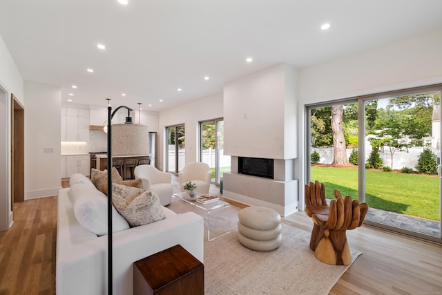 1846 Mill Plain Rd, Fairfield, CT 06824 - living room featuring a glass covered fireplace, recessed lighting, and light wood-style floors