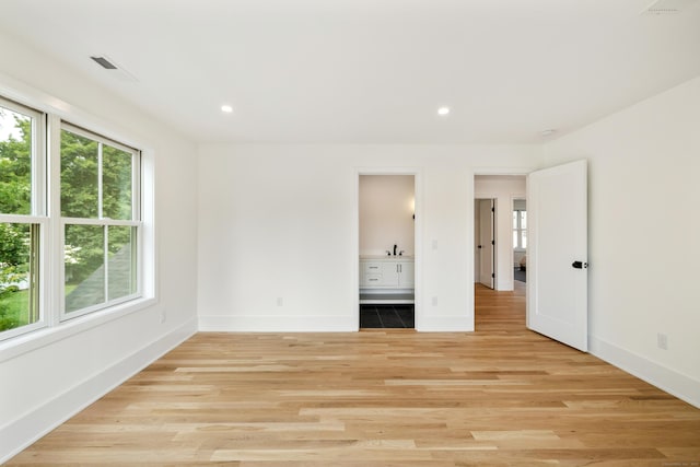 1846 Mill Plain Rd, Fairfield, CT 06824 - unfurnished bedroom with multiple windows, light wood-style flooring, recessed lighting, and ensuite bath