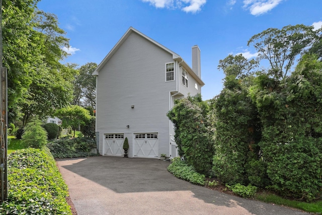 40 Pumpkin Ground Rd, Stratford, CT 06614 - view of property exterior with a chimney, a garage, and asphalt driveway
