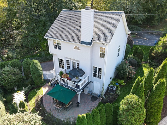 40 Pumpkin Ground Rd, Stratford, CT 06614 - back of house with a chimney, a patio, roof with shingles, a wooden deck, and view of wooded area
