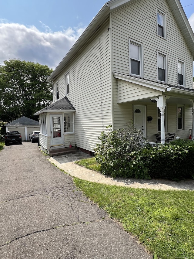 74 Starkweather St, Manchester, CT 06042 - view of side of property featuring a porch, a garage, and an outbuilding