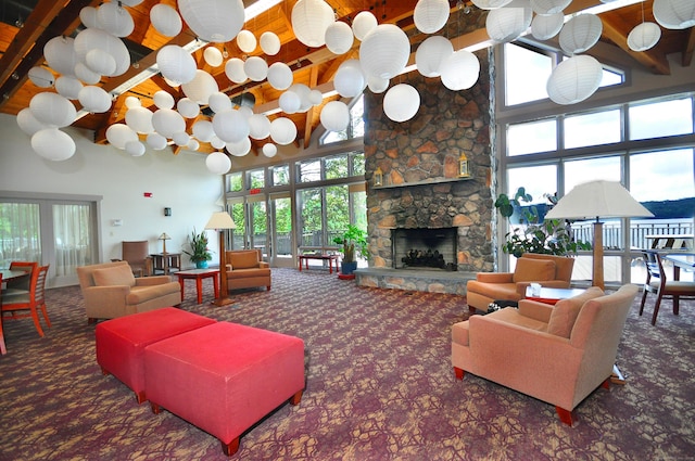 127 Weldon Ct, Goshen, CT 06756 - living area with high vaulted ceiling, carpet flooring, a stone fireplace, and a wooden ceiling with exposed beams