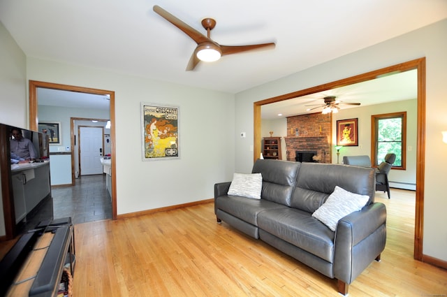 127 Weldon Ct, Goshen, CT 06756 - living room featuring a ceiling fan, baseboard heating, a brick fireplace, and light wood-style floors