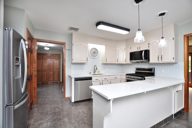 127 Weldon Ct, Goshen, CT 06756 - kitchen with appliances with stainless steel finishes, a peninsula, tasteful backsplash, white cabinetry, and light countertops