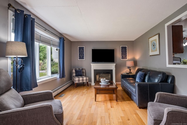 309 Russo Dr, Hamden, CT 06518 - living room with light wood-style floors, a baseboard radiator, and a fireplace
