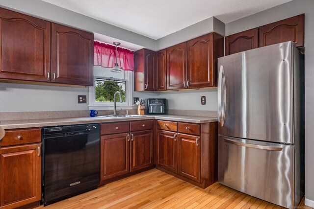 309 Russo Dr, Hamden, CT 06518 - kitchen with freestanding refrigerator, black dishwasher, light wood-style floors, and light countertops
