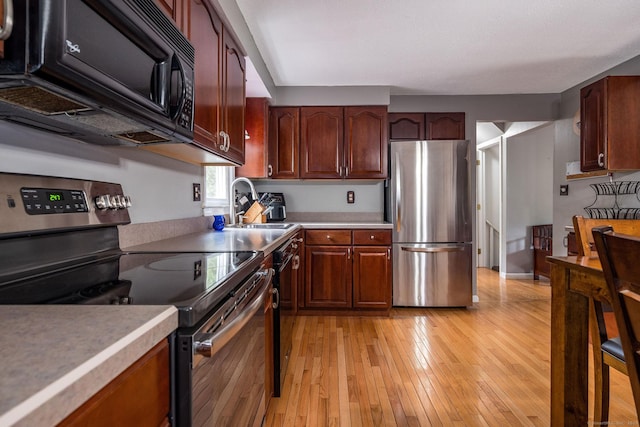 309 Russo Dr, Hamden, CT 06518 - kitchen with black appliances, light wood finished floors, and light countertops