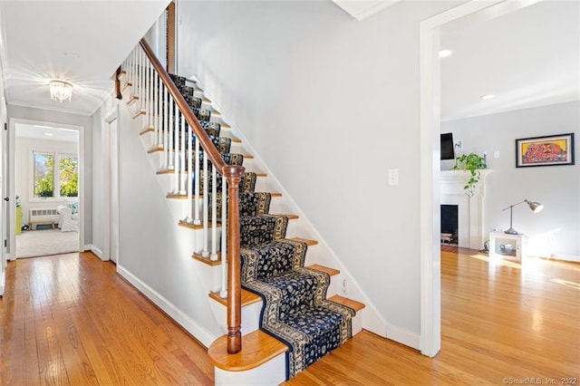 154 Mohawk Dr, West Hartford, CT 06117 - staircase with wood finished floors, radiator heating unit, ornamental molding, recessed lighting, and a fireplace with flush hearth