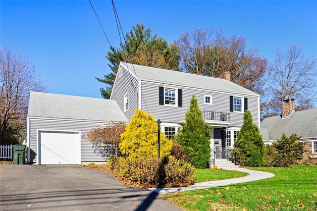 154 Mohawk Dr, West Hartford, CT 06117 - view of front of home with a garage, driveway, a front lawn, a balcony, and a chimney