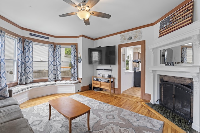 135 W Thames St, Norwich, CT 06360 - living area featuring ceiling fan, a brick fireplace, light wood-style floors, and ornamental molding
