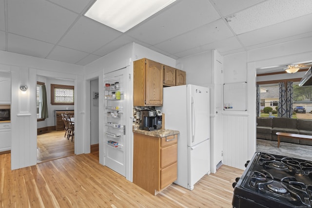 135 W Thames St, Norwich, CT 06360 - kitchen with freestanding refrigerator, a paneled ceiling, black gas range, light wood-type flooring, and healthy amount of natural light