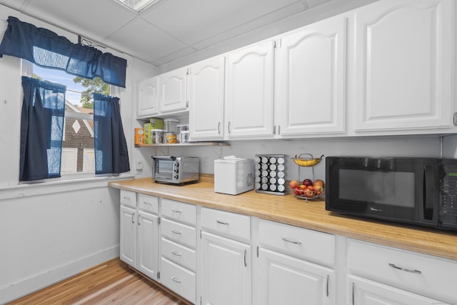 135 W Thames St, Norwich, CT 06360 - kitchen featuring black microwave, light wood finished floors, white cabinetry, and open shelves