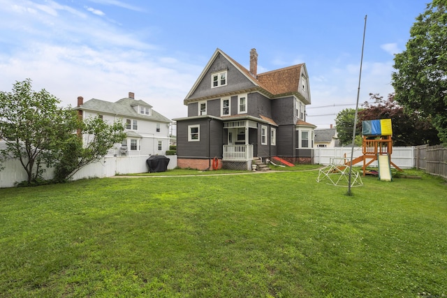 135 W Thames St, Norwich, CT 06360 - back of property with a fenced backyard, a chimney, a playground, and roof with shingles