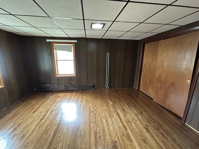 306 Divinity St, Bristol, CT 06010 - unfurnished room featuring a baseboard radiator, wood finished floors, a paneled ceiling, and wood walls