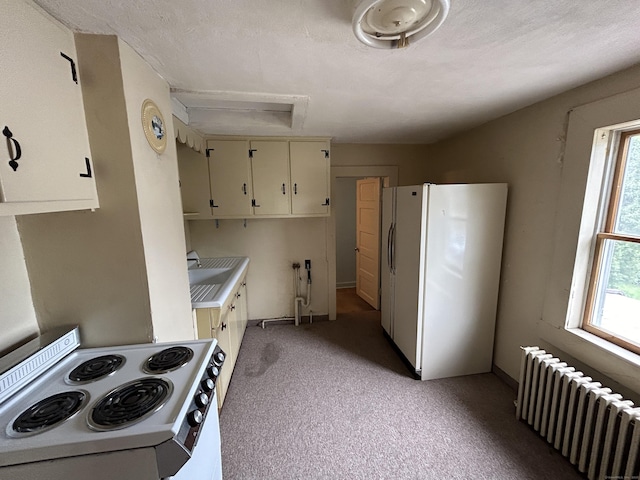 306 Divinity St, Bristol, CT 06010 - kitchen with white appliances, radiator heating unit, light carpet, cream cabinets, and light countertops