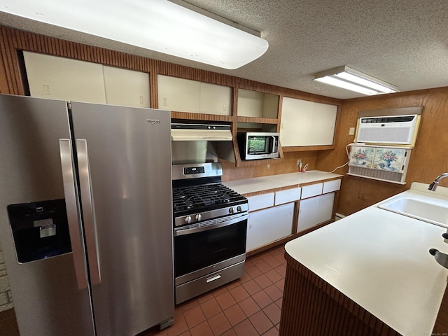 306 Divinity St, Bristol, CT 06010 - kitchen featuring appliances with stainless steel finishes, ventilation hood, a wall mounted AC, dark tile patterned flooring, and light countertops