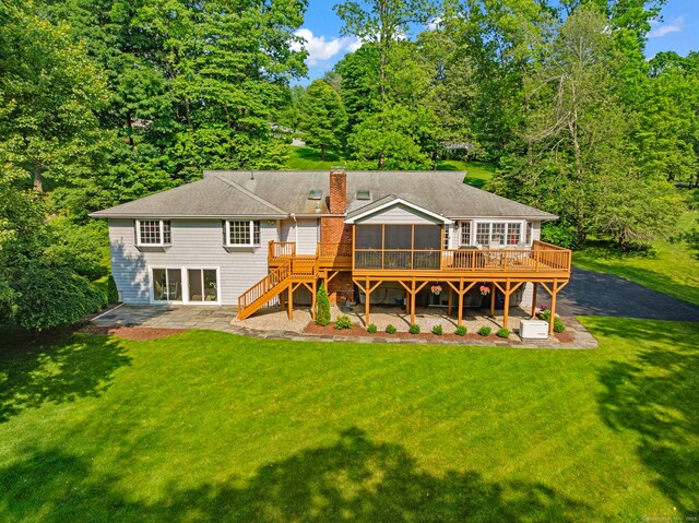 115 Remington Rd, Ridgefield, CT 06877 - back of property with a sunroom, stairway, a wooden deck, a lawn, and a patio
