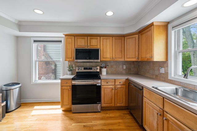 17 Glenwood Ave, Norwalk, CT 06854 - kitchen featuring appliances with stainless steel finishes, light wood-type flooring, crown molding, light countertops, and tasteful backsplash