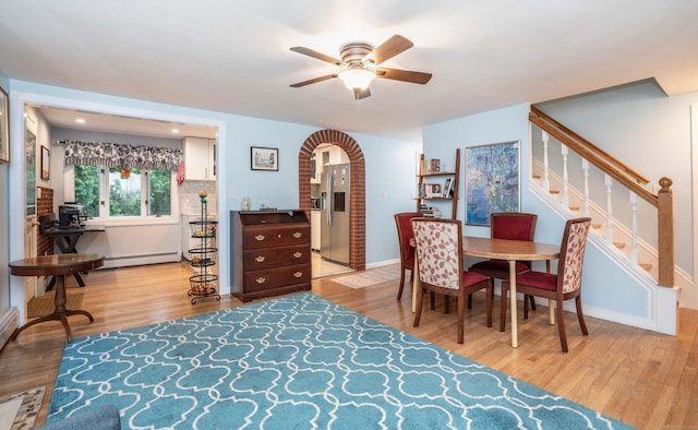 244 Stanwood Dr, New Britain, CT 06053 - dining area with a baseboard radiator, ceiling fan, wood finished floors, arched walkways, and stairway