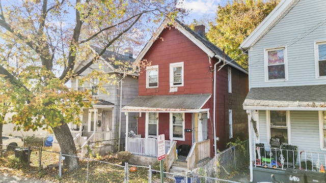 666 Orchard St, New Haven, CT 06511 - view of front of house featuring covered porch, roof with shingles, a chimney, and a fenced front yard