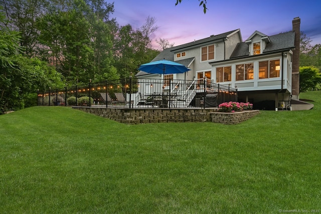 7 Forest View Dr, Newtown, CT 06482 - back of property at dusk with a chimney, a lawn, a sunroom, a patio, and a shingled roof