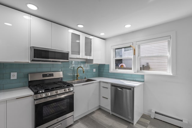 94 Prospect Ave, West Haven, CT 06516 - kitchen with stainless steel appliances, a baseboard heating unit, white cabinets, light countertops, and modern cabinets