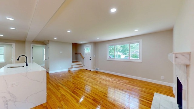 32 Miles Standish Dr, West Hartford, CT 06107 - unfurnished living room featuring light wood-style floors, stairs, recessed lighting, and a fireplace