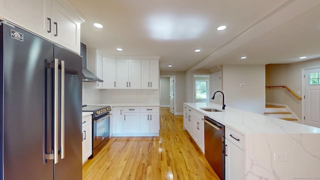 32 Miles Standish Dr, West Hartford, CT 06107 - kitchen with stainless steel appliances, wall chimney exhaust hood, light wood-style flooring, white cabinetry, and recessed lighting