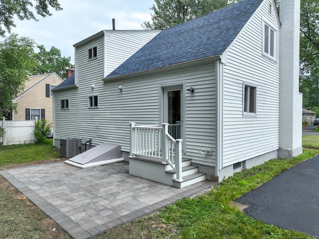 32 Miles Standish Dr, West Hartford, CT 06107 - back of property with a patio area, roof with shingles, and a chimney