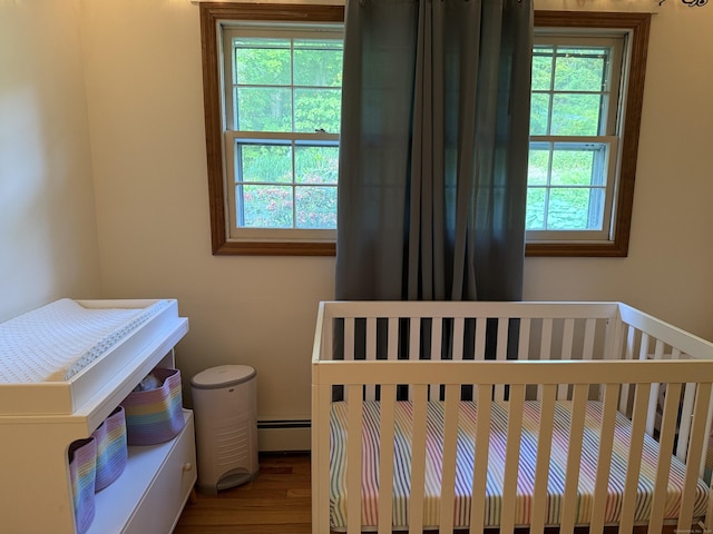 175 Luna Trail Ext, Southbury, CT 06488 - bedroom with a baseboard heating unit, wood finished floors, and a crib