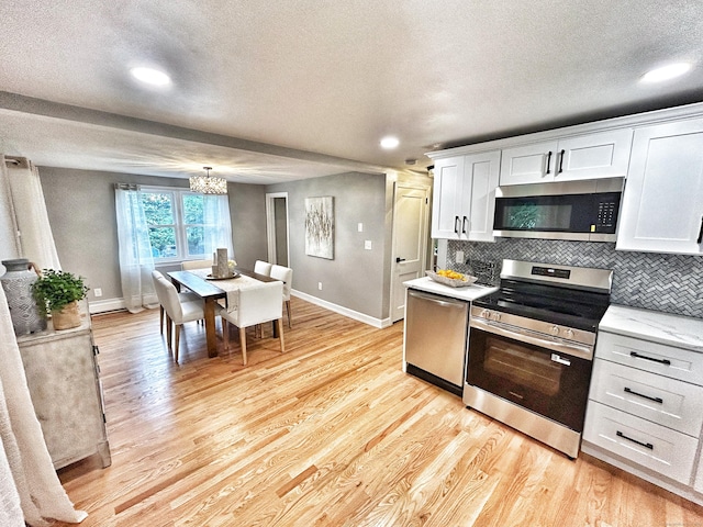 342 Middle Tpke E, Manchester, CT 06040 - kitchen with appliances with stainless steel finishes, a textured ceiling, light wood-style floors, white cabinetry, and decorative backsplash