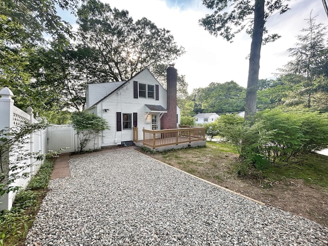 342 Middle Tpke E, Manchester, CT 06040 - rear view of house featuring a deck, a chimney, gravel driveway, and a gate