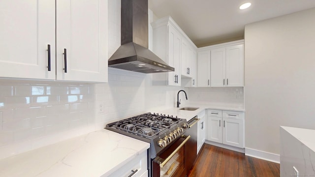 274 High St, Fairfield, CT 06824 - kitchen with wall chimney range hood, stainless steel range, light stone counters, white cabinets, and tasteful backsplash