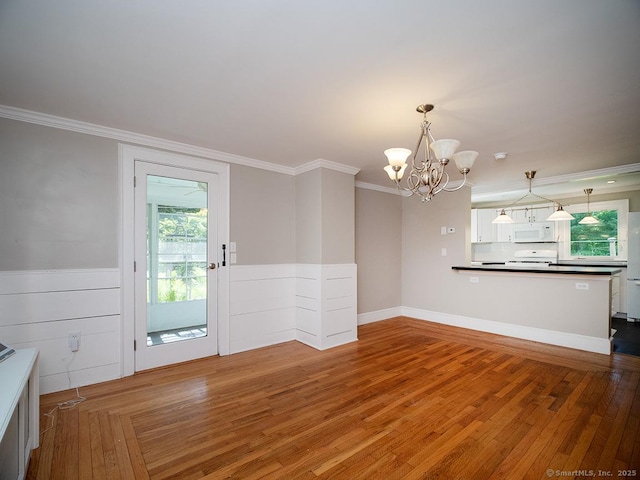 42 Homewood Ave, North Haven, CT 06473 - unfurnished dining area with a chandelier, crown molding, plenty of natural light, wood finished floors, and a wainscoted wall