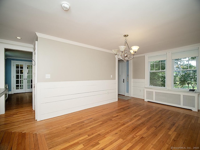 42 Homewood Ave, North Haven, CT 06473 - empty room with radiator heating unit, a smoke detector, ornamental molding, a chandelier, and a wainscoted wall
