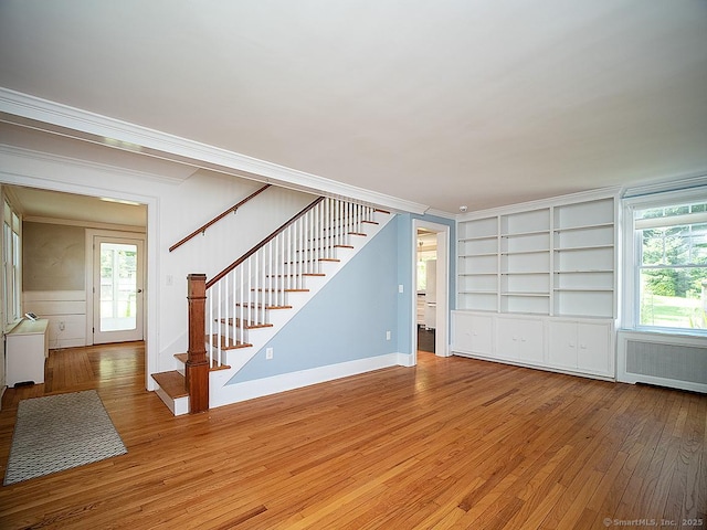 42 Homewood Ave, North Haven, CT 06473 - unfurnished living room featuring hardwood / wood-style flooring, stairs, ornamental molding, built in shelves, and radiator heating unit
