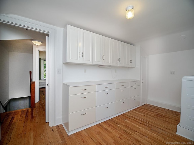 42 Homewood Ave, North Haven, CT 06473 - kitchen with light wood-type flooring, white cabinets, washer / clothes dryer, light countertops, and lofted ceiling