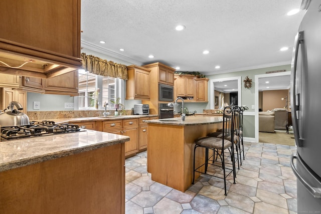 1199 Cornerstone Ct, Cheshire, CT 06410 - kitchen featuring stainless steel appliances, crown molding, light stone countertops, a center island with sink, and recessed lighting